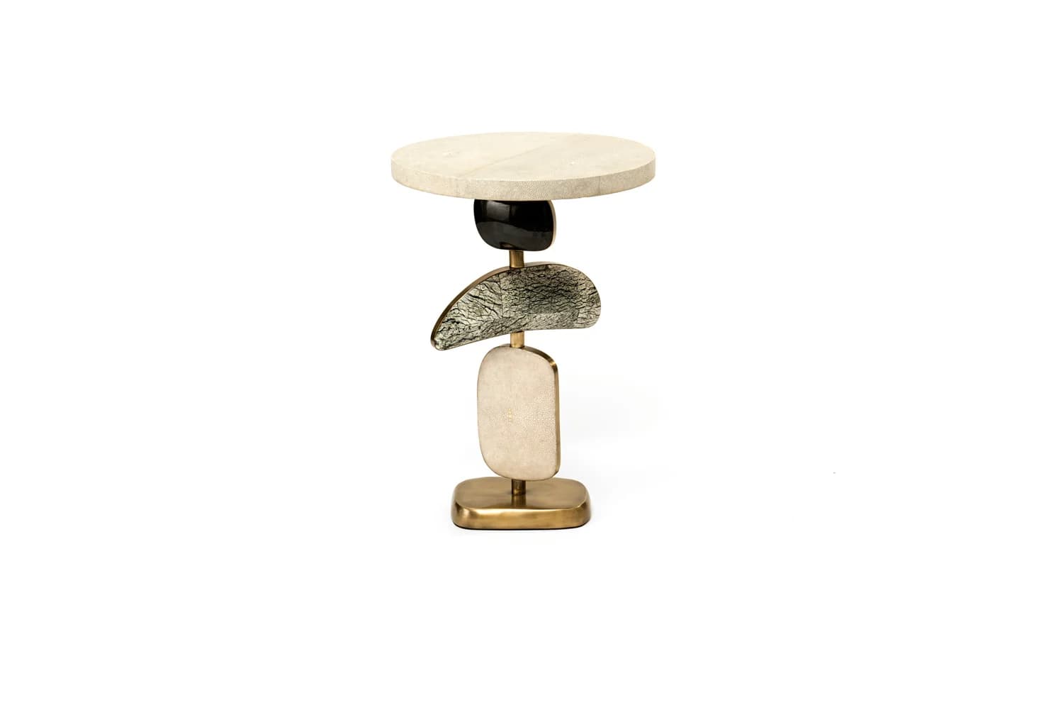 A small, round-top accent table featuring a distinctive sculptural base composed of stacked organic shapes in varied materials and finishes, resting on a polished brass plinth. — 3D model