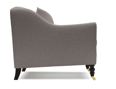 A single-seater armchair upholstered in a light grey textured fabric. The chair features a high back that curves gently into the arms, a deep seat cushion, and a lumbar pillow. It is supported by four dark wooden legs with brass casters on the front two legs. — 3D model
