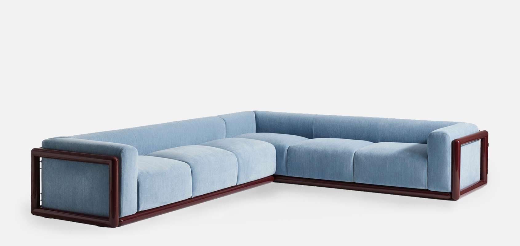 An L-shaped sectional sofa featuring a prominent dark wood frame and light blue fabric upholstery. The sofa comprises multiple modular-looking sections, with seat and back cushions exhibiting vertical channel tufting. The low-profile design emphasizes the clean lines of the exposed wooden structure. — 3D model