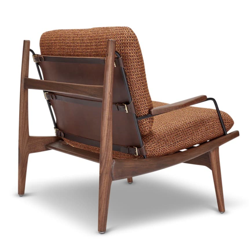 A mid-century modern armchair featuring a wooden frame, upholstered seat and backrest, and leather straps. The armchair has a distinctive silhouette with angled legs and armrests. The backrest is supported by a woven leather panel and held in place by adjustable leather straps with brass buckles. The seat and back cushions are upholstered in a textured, woven fabric. — 3D model