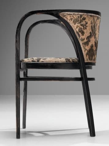A dark-stained bentwood armchair featuring a distinctive barrel-back design. The frame is constructed from elegantly curved wood, forming integrated armrests and a supportive backrest. Both the seat and the inner backrest are upholstered in a patterned fabric, displaying a traditional damask or paisley motif in shades of dark brown/black and beige/gold. The chair stands on four straight legs, connected by simple stretchers for stability. The overall aesthetic suggests an early 20th-century or classic design. — 3D model