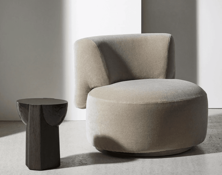 A contemporary, armless lounge chair upholstered in a light beige fabric, featuring a curved backrest and a circular seat, designed for comfortable, relaxed seating. The base suggests a swivel mechanism. — 3D model