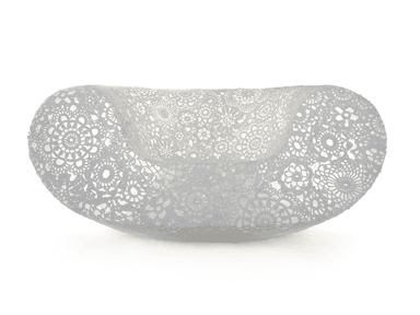 A modern, sculptural chaise lounge featuring an intricate, openwork crochet or lace-like pattern across its entire surface. The piece is curved and elongated, designed for comfortable reclining, and appears to be made from a light-colored, possibly synthetic resin material. — 3D model