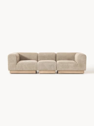 A modular upholstered bench consisting of three individual, backless sections. Each section is covered in a textured, light beige fabric and sits upon a recessed base made of light-toned wood. The design is contemporary and minimalist, emphasizing clean lines and a low profile. — 3D model