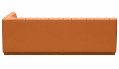 A corner booth-style seating unit with a fluted backrest and upholstered cushions. The unit is L-shaped, designed to accommodate multiple individuals. The upholstery features a consistent sheen, suggesting a synthetic leather or vinyl material. The design incorporates vertical channeling on the backrest and smooth surfaces on the seat and arms. — 3D model