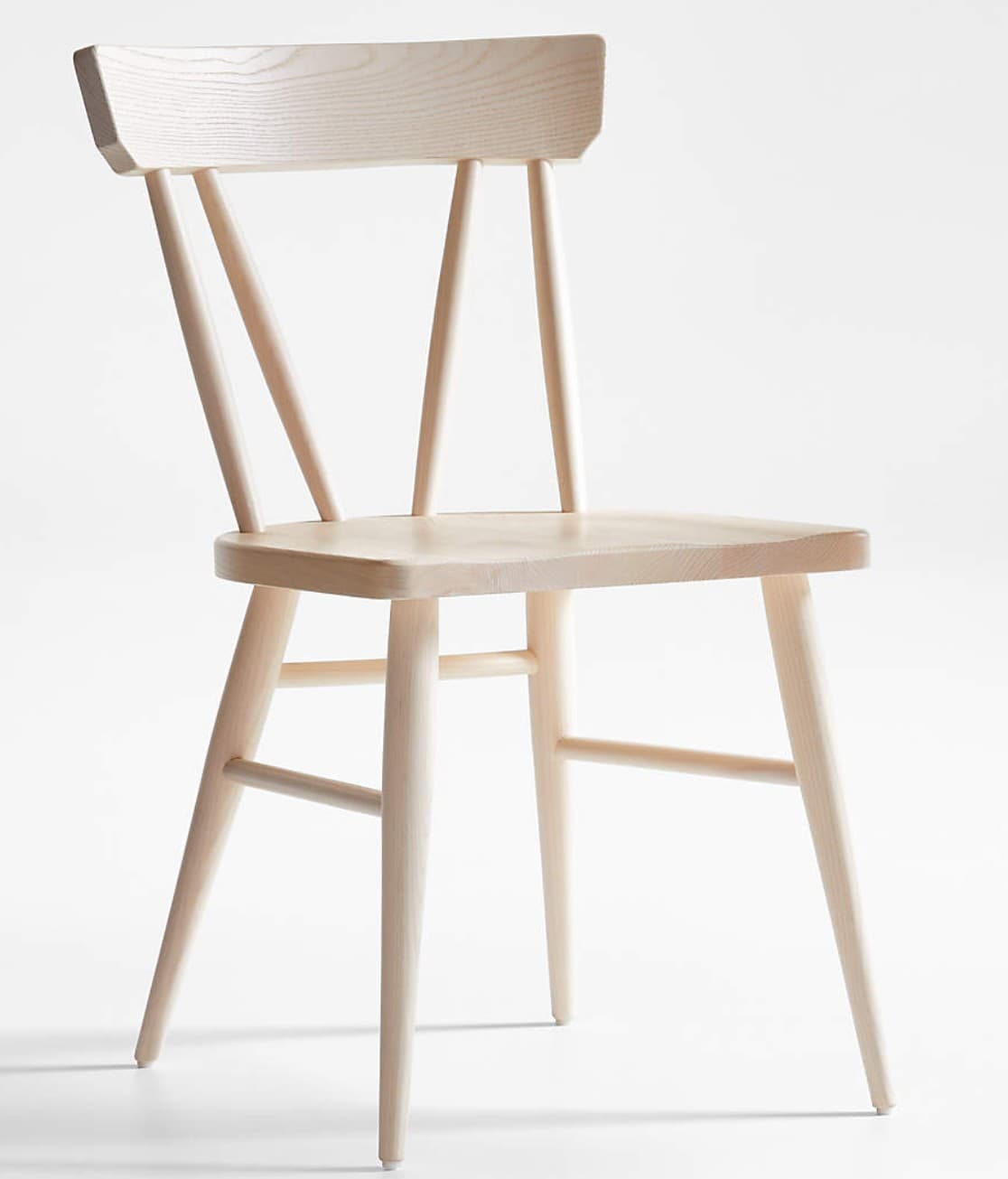 A light-colored wooden dining chair featuring a contoured seat, a broad, gently curved backrest with three vertical spindles, and four tapered legs connected by lower stretchers. — 3D model