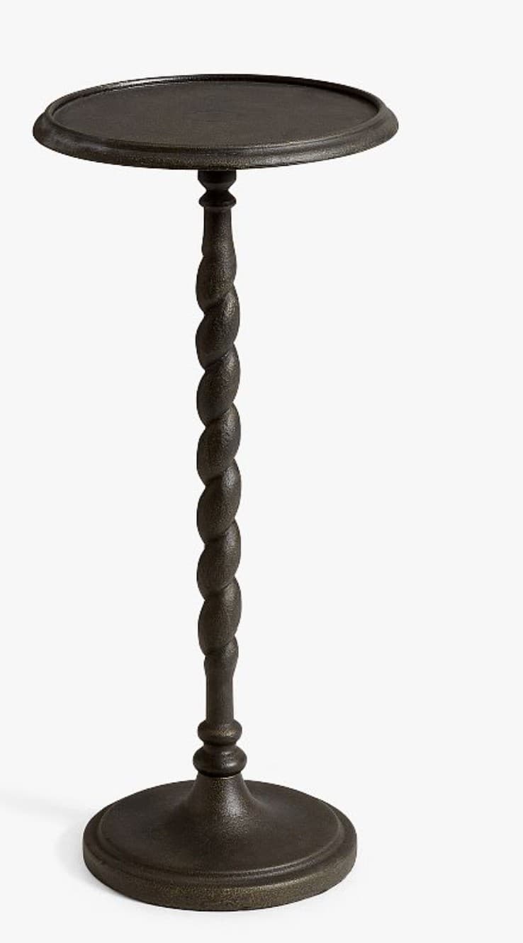A small, dark bronze-colored accent table featuring a distinctive barley twist central column. The table has a round, tray-style top with a slightly raised edge and a matching round, fluted base. The entire piece appears to be made of metal, likely cast iron, with a textured, matte finish. — 3D model
