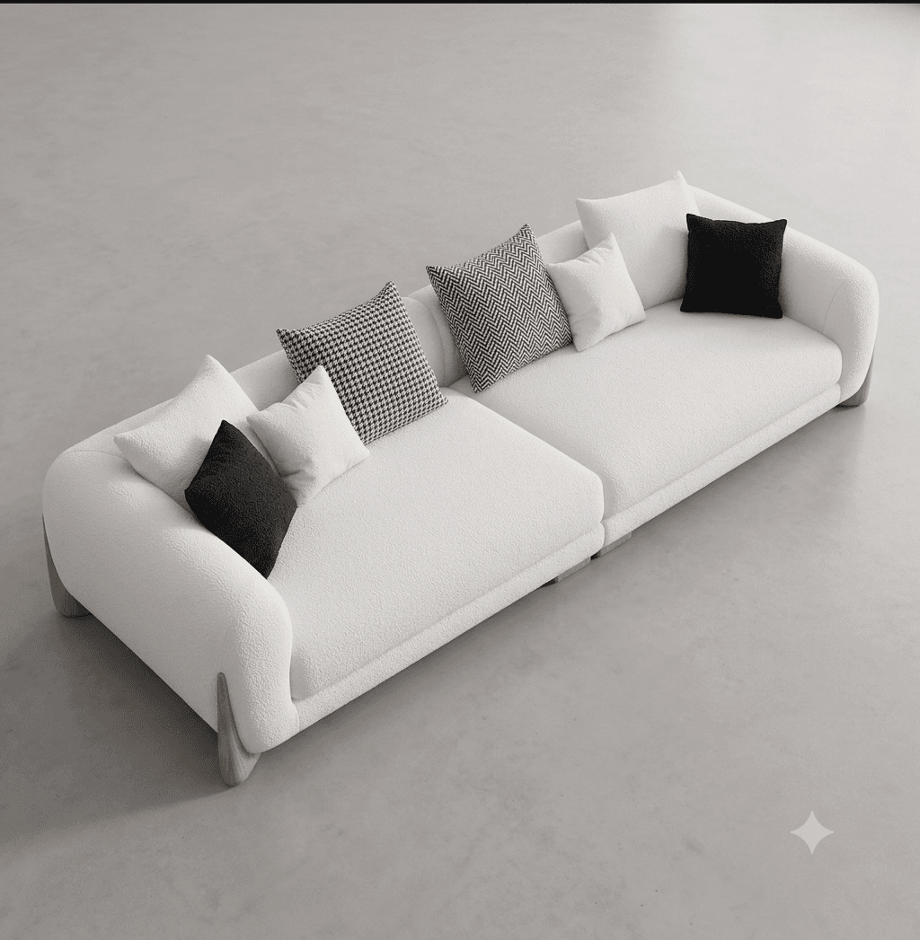 A contemporary, modular sectional sofa upholstered in white boucle fabric, featuring rounded edges and a low-profile wooden base. The sofa is presented as two connected sections, adorned with several throw pillows in varying sizes and patterns, including solid black, solid white, houndstooth, and chevron. — 3D model