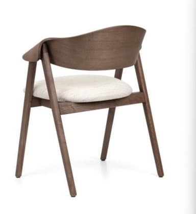 A contemporary dining armchair featuring a dark walnut-finished wooden frame with a curved backrest and integrated armrests. The seat is upholstered in a light, textured fabric, complementing the slender, tapered legs. — 3D model