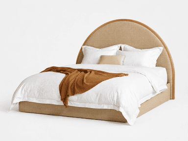 A contemporary bed featuring a distinctive arched headboard constructed with a natural wood frame and a woven cane or rattan insert. The bed base is upholstered in a neutral beige fabric, complementing the natural textures of the headboard. It is shown dressed with crisp white bedding and a warm brown throw blanket. — 3D model