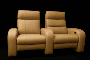A pair of connected recliners upholstered in a tan leather-like material. Each recliner features a high back with segmented cushioning and padded armrests. The recliner on the right shows a visible control panel embedded in the armrest, suggesting electronic reclining functionality. The overall design is modern and appears to be intended for home theater or lounge seating. — 3D model