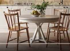 A small, round white pedestal table, featuring a clean, simple design suitable for various interior styles. The table has a circular top and a sturdy central pedestal base with four splayed, scrolled feet. — 3D model