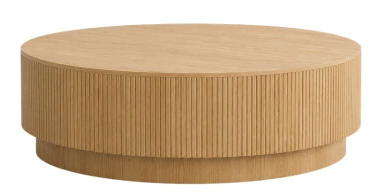 A round coffee table with a distinctive drum-shaped body made from light-toned wood, likely oak. The main body features vertical reeding or fluting, providing a textural element, while the top surface is smooth and flat. The table sits on a slightly recessed, plain circular plinth base, maintaining a clean and cohesive silhouette. The overall design is contemporary and minimalist, emphasizing natural materials and subtle detailing. — 3D model