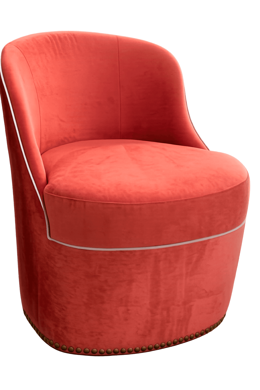 A plush armchair with a rounded back and seat, upholstered in a coral-colored velvet fabric. The chair features a subtle piped trim along the edge of the seat and a decorative border of brass nailheads at the base. The overall form suggests a contemporary yet classic design. — 3D model