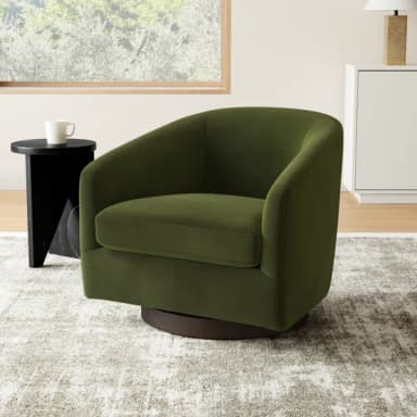A contemporary armchair with a rounded silhouette and upholstered in a textured fabric. It features a swivel base for 360-degree rotation. The chair has a deep seat and a curved backrest that extends into low-profile armrests, creating a cohesive, enveloping form. The base is a circular, dark-finished disc. — 3D model
