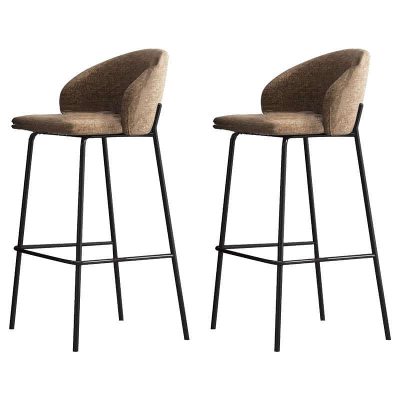 A modern bar stool featuring a minimalist black metal frame and a curved, upholstered seat and backrest in a neutral, textured fabric. The stool is designed for elevated seating at bars or counters, with a built-in footrest. — 3D model