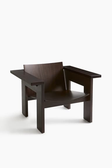 A sturdy, dark brown wooden armchair with a minimalist, angular design. It features broad, flat armrests, a straight backrest, and a slightly contoured seat, all supported by thick, block-like legs. The wood grain is visible, adding texture to its dark finish. — 3D model