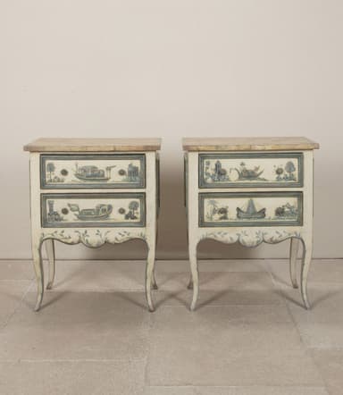 A pair of matching nightstands with two drawers each. The front panels of the drawers and the lower skirt are adorned with hand-painted blue and white scenic details, featuring boats and architectural elements. The nightstands have a distressed cream-colored finish and are supported by four cabriole legs. The top surface appears to be a different material, possibly a veneer or stone. — 3D model