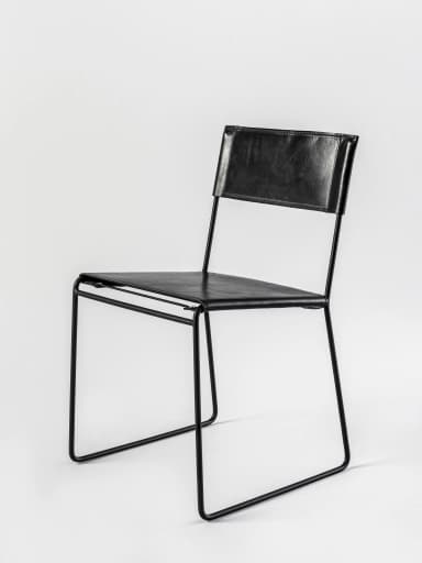 A contemporary armless chair featuring a minimalist design with a black metal sled frame and black leather upholstery for the seat and back. — 3D model