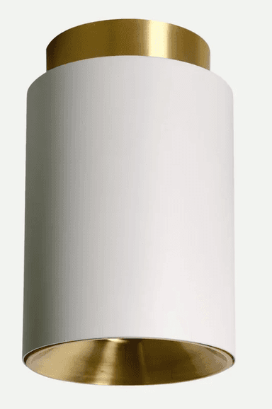 A modern cylindrical light fixture designed for semi-flush ceiling mounting, featuring a matte white exterior and a contrasting polished brass interior reflector and top trim. — 3D model