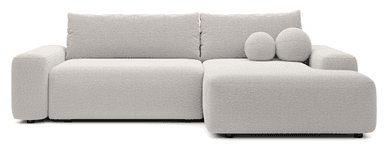 A sectional sofa with a plush, textured fabric upholstery. The sofa features a low profile, deep seating, and square arms. It is configured as an L-shape, with a longer section on the left and a shorter chaise or extension on the right. Two spherical throw pillows with the same fabric are placed on the right section. The sofa is supported by short, dark-colored legs. — 3D model
