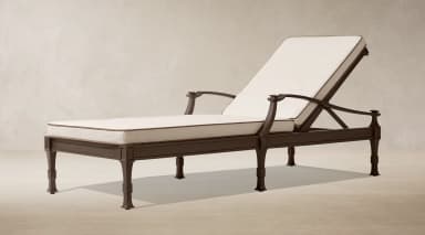 A dark bronze finished metal chaise lounge designed for outdoor use, featuring an adjustable backrest and thick, off-white cushions with dark brown piping. The frame exhibits classic design elements with shaped legs and armrests. — 3D model