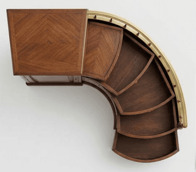 An exquisite Art Deco style bar cabinet featuring a distinctive curved form and rotating functionality. It is constructed from dark wood, likely walnut, with a rectangular top surface and interior trays adorned with a finely crafted herringbone veneer pattern. The curved exterior edge is elegantly finished with a polished brass rail. The cabinet's unique design incorporates multiple fan-shaped, segmented trays that appear to slide or rotate outwards, offering organized storage for bar essentials. — 3D model