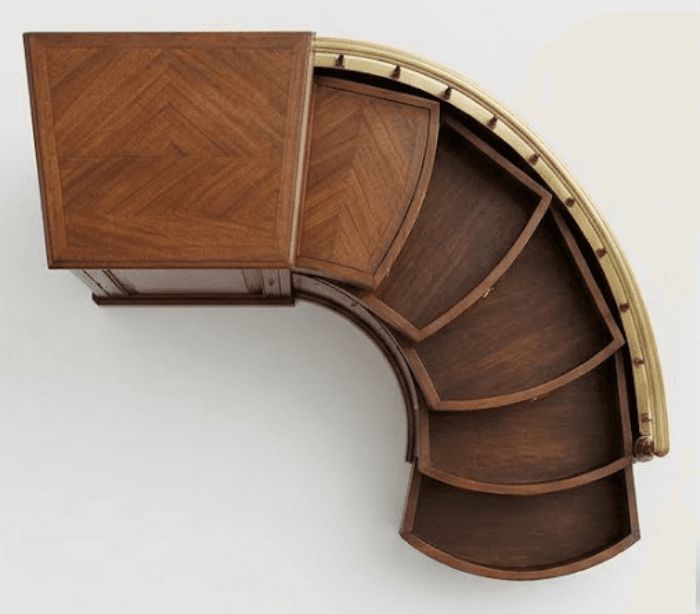 An exquisite Art Deco style bar cabinet featuring a distinctive curved form and rotating functionality. It is constructed from dark wood, likely walnut, with a rectangular top surface and interior trays adorned with a finely crafted herringbone veneer pattern. The curved exterior edge is elegantly finished with a polished brass rail. The cabinet's unique design incorporates multiple fan-shaped, segmented trays that appear to slide or rotate outwards, offering organized storage for bar essentials. — 3D model