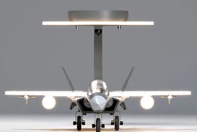 A ceiling-mounted light fixture featuring a detailed model of a fighter jet, surrounded by illuminated contours that suggest a flight path or abstract wings. The primary color of the jet is grey, with white and red accents. The light emitted is a warm white. — 3D model