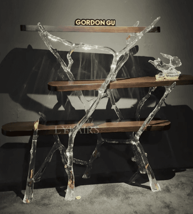 A freestanding multi-tiered display shelf featuring an organic, branch-like polished metal frame and four rectangular wooden shelves. The frame has a fluid, sculptural appearance, supporting the dark-toned display surfaces. — 3D model