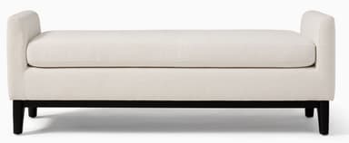 An off-white upholstered bench featuring integrated, low-profile armrests and supported by dark, tapered wooden legs. It has a single, removable seat cushion. — 3D model