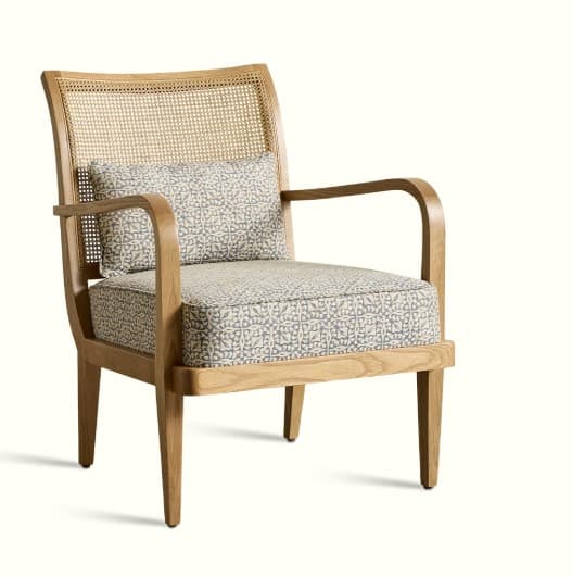 A wooden armchair with a cane back and upholstered seat and back cushion. The chair has a light wood frame with curved armrests and four tapered legs. The upholstery features a repeating geometric pattern in grey and cream. — 3D model