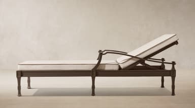 A dark bronze finished metal chaise lounge designed for outdoor use, featuring an adjustable backrest and thick, off-white cushions with dark brown piping. The frame exhibits classic design elements with shaped legs and armrests. — 3D model