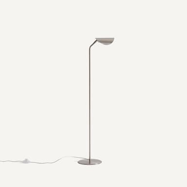 A sleek, minimalist floor lamp featuring a slender vertical stem, a flat circular base, and a semi-circular shade angled upwards. The entire lamp is rendered in a uniform brushed metal finish. — 3D model