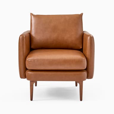 A modern armchair upholstered in brown leather. It features a boxy frame with rounded armrests and a slightly reclined backrest. The seat is composed of two thick cushions. The armchair is supported by four tapered wooden legs, angled outwards. — 3D model