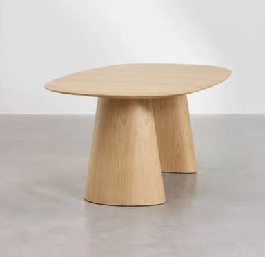 An organically shaped, light wood dining table with a smooth, matte finish. The tabletop is elongated and subtly rounded at the edges. It is supported by two distinctive, solid wooden bases that are wider at the bottom and taper upwards towards the tabletop, featuring a curved, almost sculptural form. The material appears to be solid wood, possibly oak, with a visible grain pattern. — 3D model