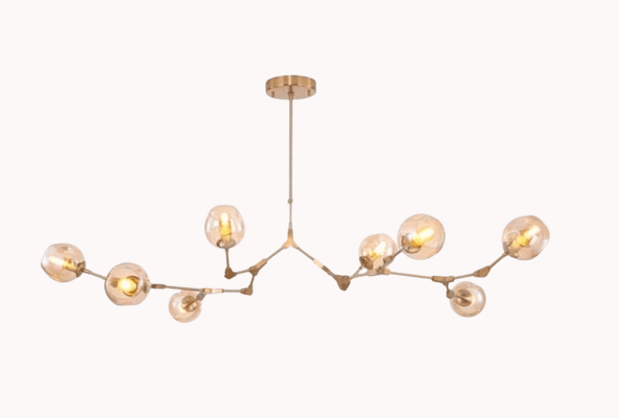 A modern chandelier with a branching structure supporting multiple spherical glass shades. The fixture is suspended from a ceiling mount by a thin rod. The arms extend outwards in an asymmetrical, organic pattern, each terminating in a glass globe housing a light bulb. The metal components appear to be a brushed gold or brass finish. — 3D model