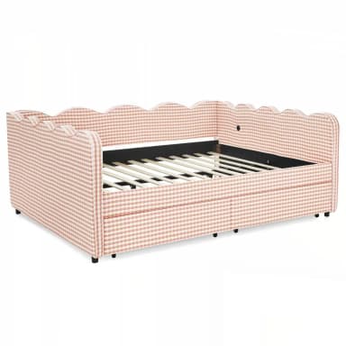 A daybed upholstered in a pink and white gingham fabric with a scalloped headboard and side rails. The frame features a slatted mattress support and appears to have a pull-out trundle bed mechanism beneath the main seating area. Small black feet support the structure. — 3D model