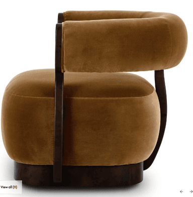An Art Deco style barrel armchair upholstered in plush brown velvet with a dark, possibly burl wood, veneer frame. The chair features a curved back and integrated arms, all padded and upholstered. The wooden frame provides structural support, flowing from the base up to encompass the back and arms. The seat cushion is thick and round, resting on a sturdy, rounded wooden base. — 3D model