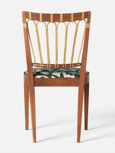 A wooden chair with a curved backrest featuring vertical, cane-wrapped spindles and a padded seat upholstered in a green fabric with a white abstract pattern. The chair has a solid wooden frame with four tapered legs. — 3D model