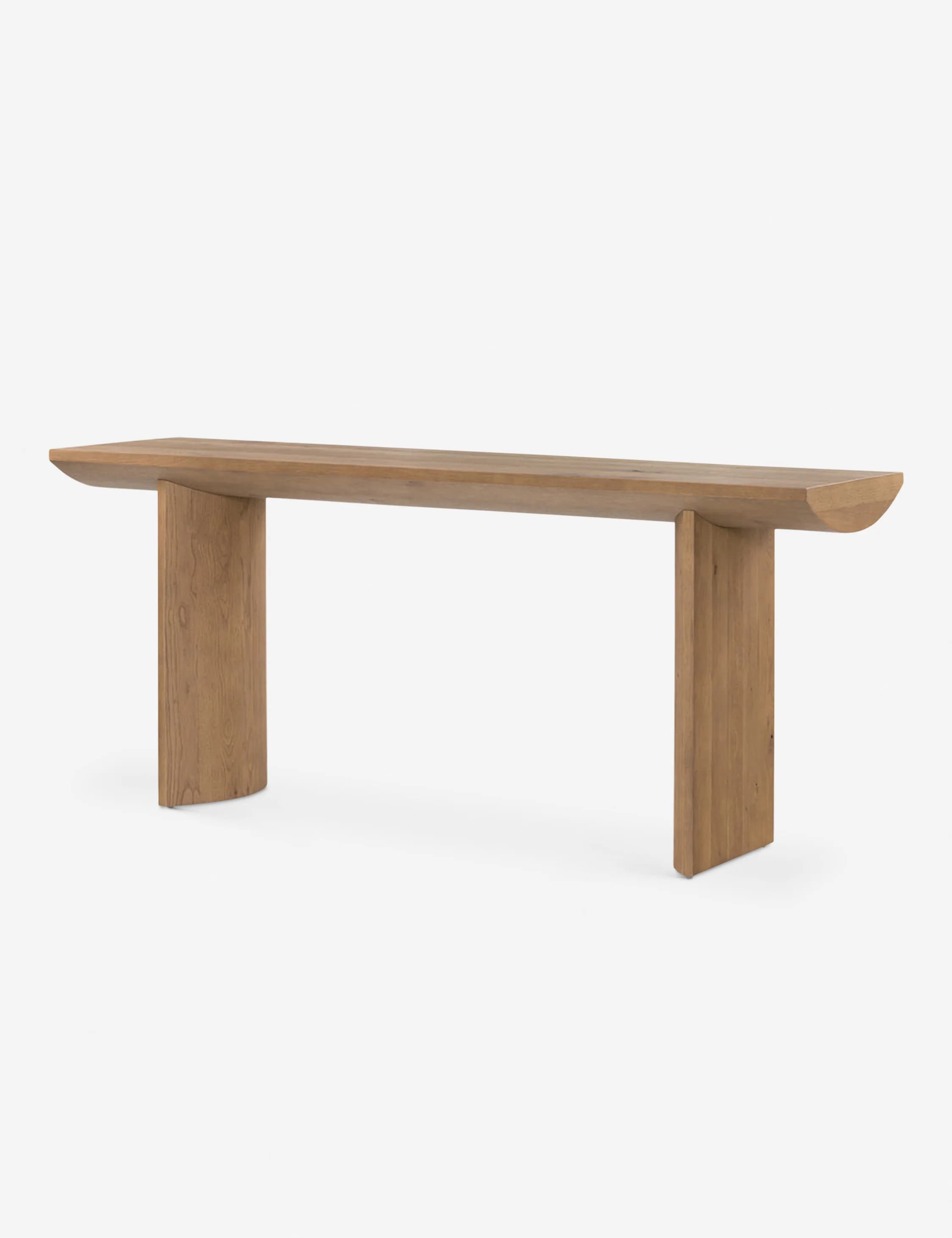 A long, narrow console table with a solid wood top and two block-like legs. The top has a gently curved edge on one side and a flat edge on the other. The legs are rectangular in shape and are positioned at the ends of the table. The wood grain is visible throughout the piece. — 3D model