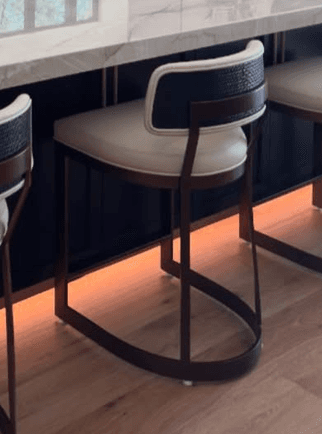A modern bar stool featuring an aged brass metal frame and white upholstered seat and backrest, with a distinctive U-shaped sled base. — 3D model