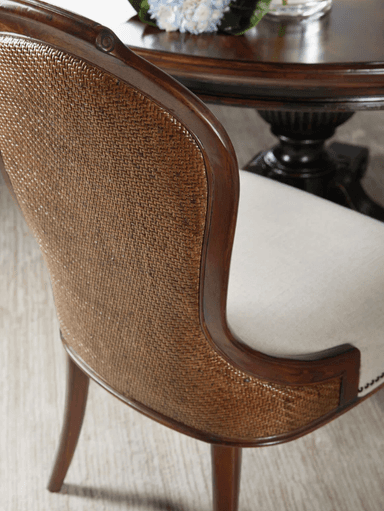 A classic armchair with a carved wooden frame and upholstered seat and back. The upholstery is a light beige linen-like fabric, tufted with decorative nailhead trim along the base of the seat cushion and the perimeter of the backrest. The wooden frame exhibits a dark brown, polished finish. The backrest has a curved, elongated shape, while the front legs feature a cabriole design with scroll details, terminating in a bulbous foot. — 3D model