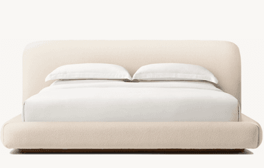 A low-profile bed frame with a rounded headboard and platform base, upholstered in a textured, light-colored fabric. The bed is dressed with white bedding, including two pillows stacked neatly. — 3D model