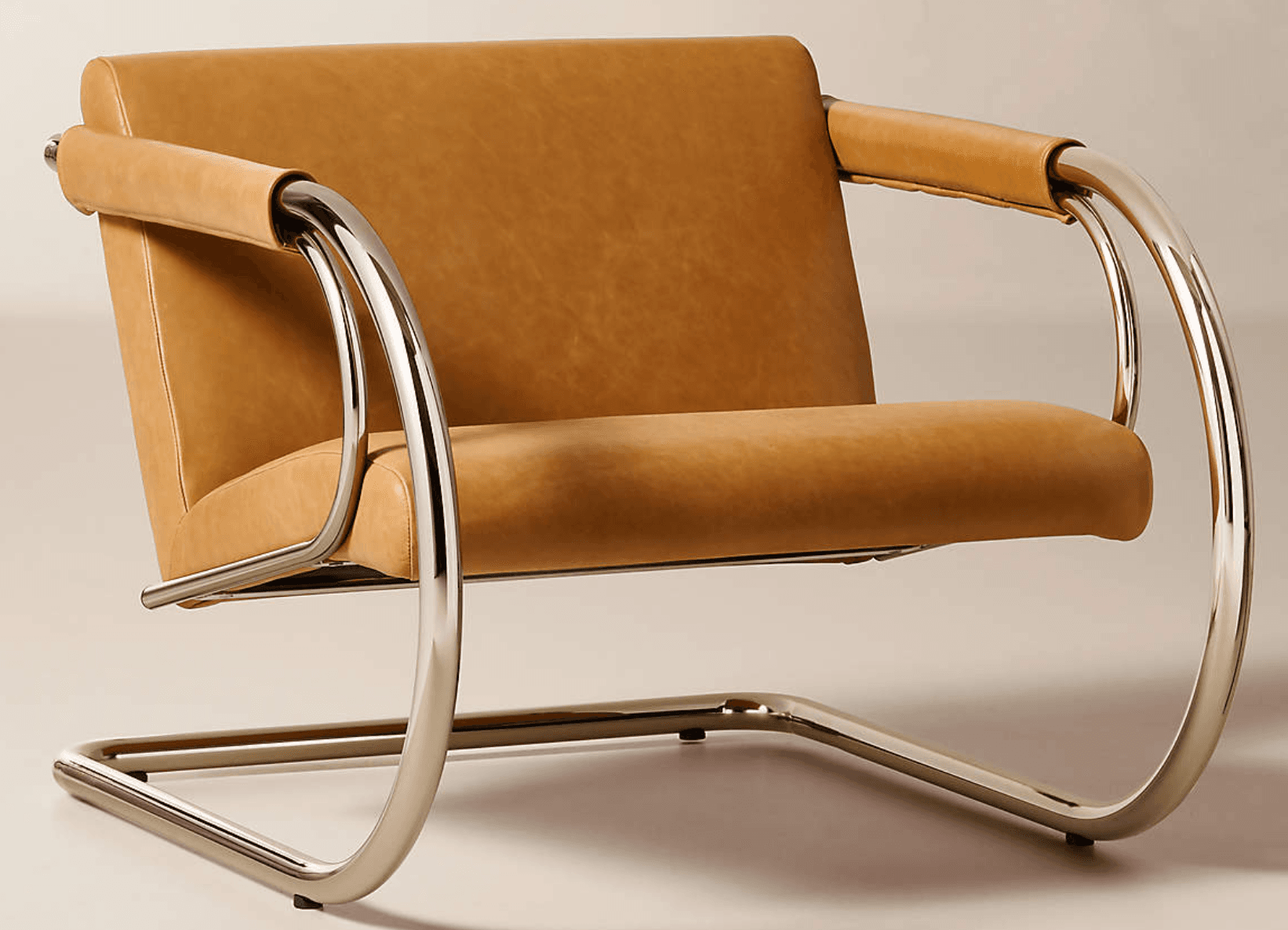 A modernist lounge chair featuring a cantilever tubular chrome frame and camel-colored leather upholstery. The frame forms continuous, polished curves for the base and armrests, which are padded with rolled leather sleeves. It has separate box cushions for the seat and back. — 3D model