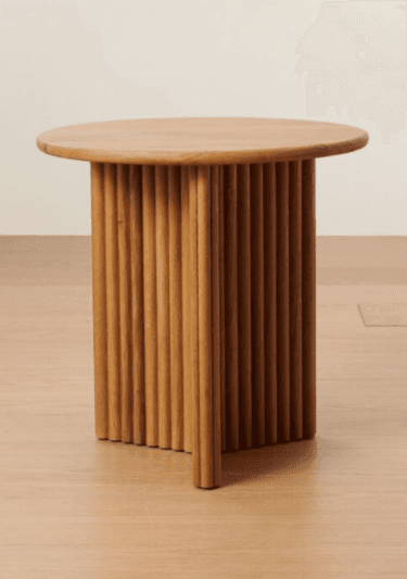 A cylindrical side table with a round top and a base composed of vertical wooden rods. The rods are closely spaced and create a fluted effect on the cylindrical body of the table. A single support rod is visible extending downwards from the tabletop, appearing to integrate with the surrounding rods. — 3D model