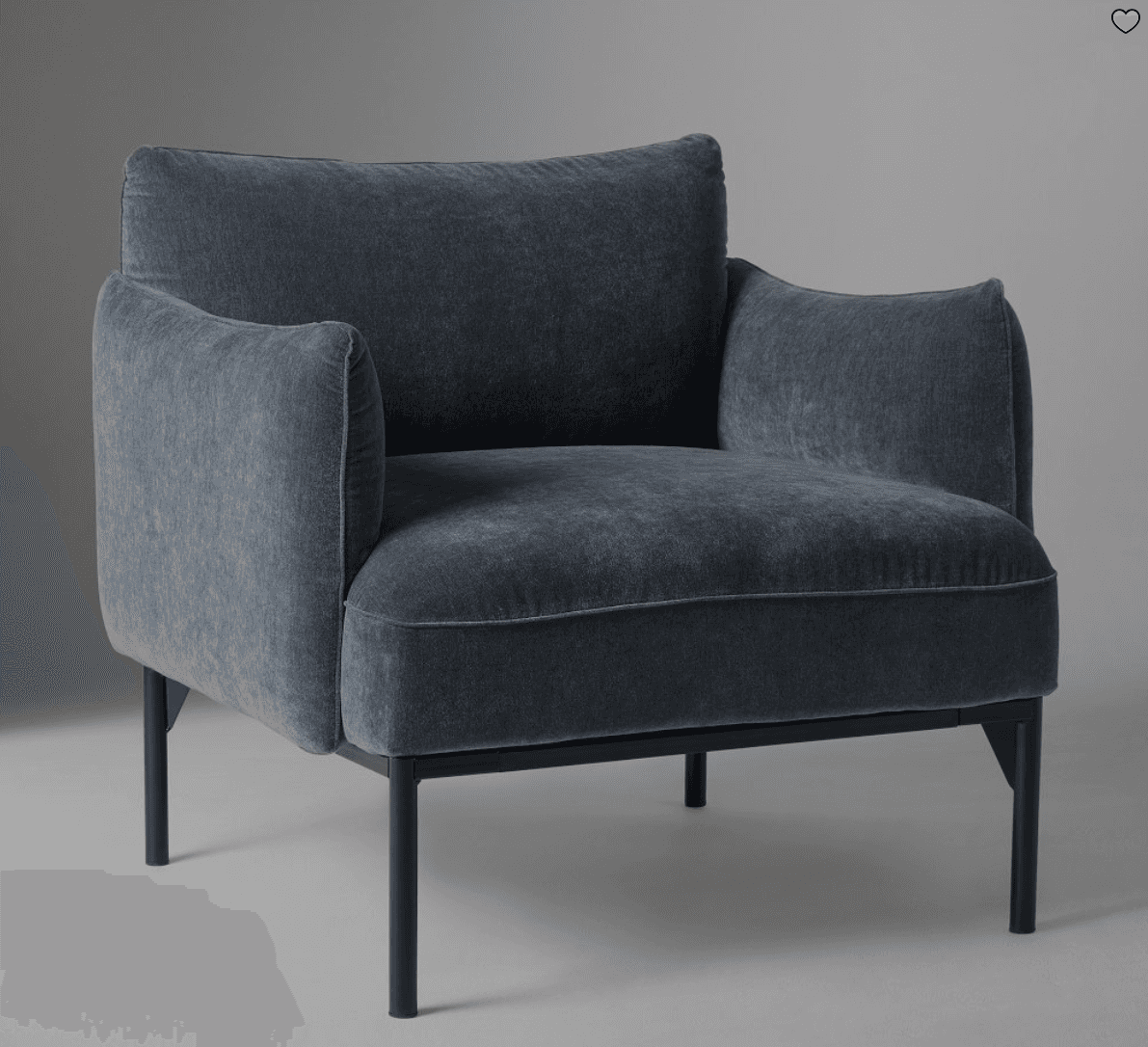 A modern armchair with a plush, upholstered seat, back, and arms, supported by a slender, dark metal frame and four thin legs. — 3D model
