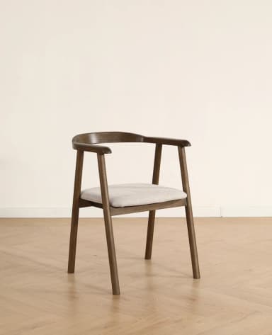 A modern dining armchair crafted from dark wood with a curved backrest and integrated armrests, featuring a light beige upholstered seat cushion. — 3D model