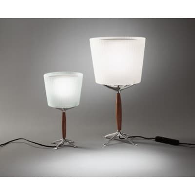 A mid-century modern table lamp featuring a fluted, frosted glass shade atop a distinct base. The shade is cylindrical with a slightly wider top and bottom opening, exhibiting a subtle ribbed texture that diffuses light softly. The stem connecting the shade to the base is a smooth, tapered wooden element, likely walnut, providing a warm contrast to the metallic base. The base is a starburst or tripod design, constructed from polished aluminum or a similar silver-toned metal, with splayed legs ending in flat, rectangular feet for stability. A black cord extends from the base for power connection. — 3D model