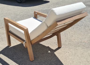 A lounge chair with a wooden frame and white upholstered cushions. The chair features adjustable backrest and armrests. The wooden frame has a natural finish, and the cushions are made of a textured fabric. Straps are visible to secure the cushions. — 3D model